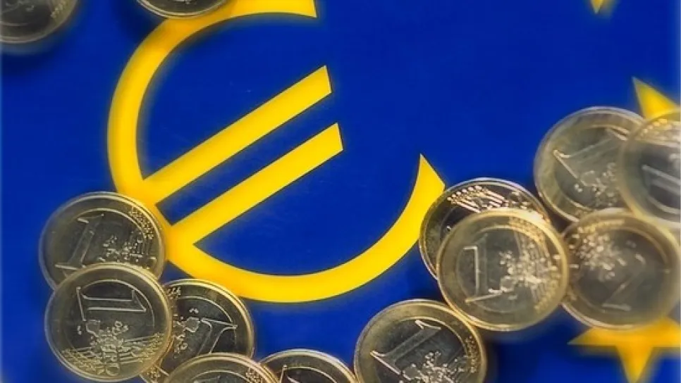 monete dell'euro distribuite su una bandiera con il simbolo dell'euro e i colori dell'Europa